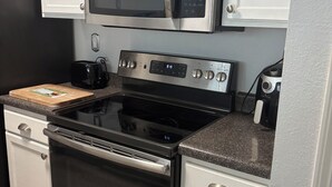 Una cocina con electrodomésticos de acero inoxidable, incluyendo un microondas, horno y tostadora.