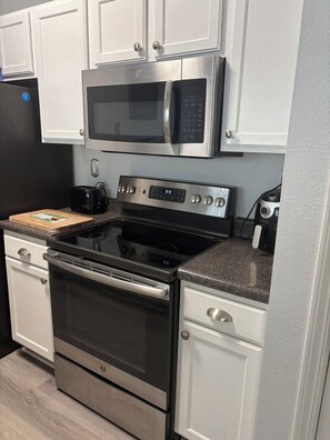 A kitchen with stainless steel appliances, including a microwave, oven, and toaster. - 2-bedroom condo on first floor in peaceful Seminole, FL-5 min from Maderia Beach (Seminole)