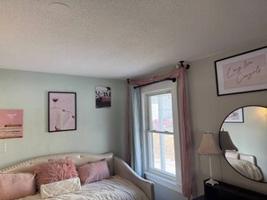 A bedroom with a bed, a window with curtains, a wall-mounted mirror, and framed pictures. - Plymouth! Close to campus, downtown and Speare (Plymouth)