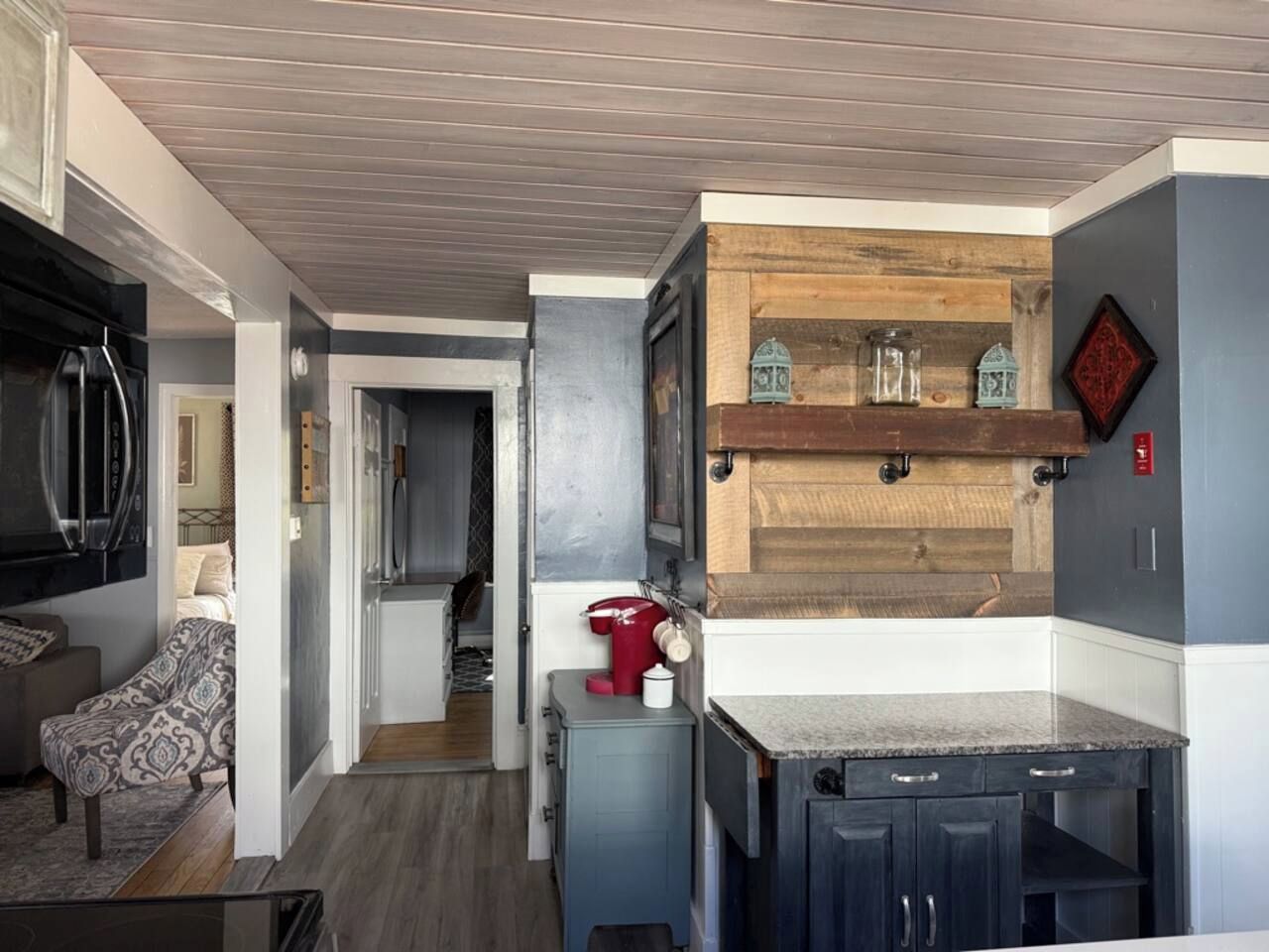 A compact kitchen with a wooden accent wall, a built-in stove, and a small countertop.