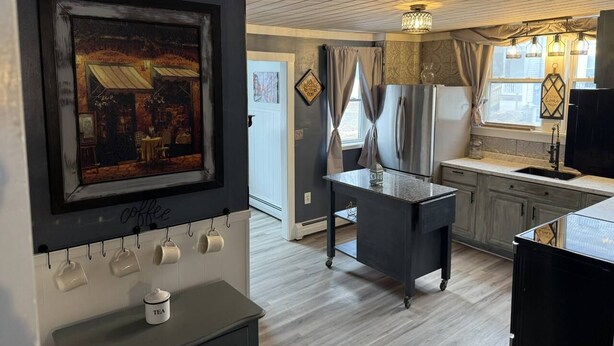 Een keuken met een koffiehoek, een eethoek met een tafel en uitzicht op buiten.