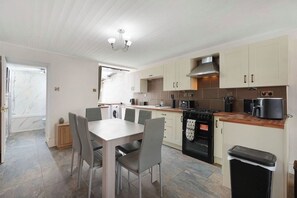 Una cocina moderna con una mesa de comedor, sillas y una estufa.