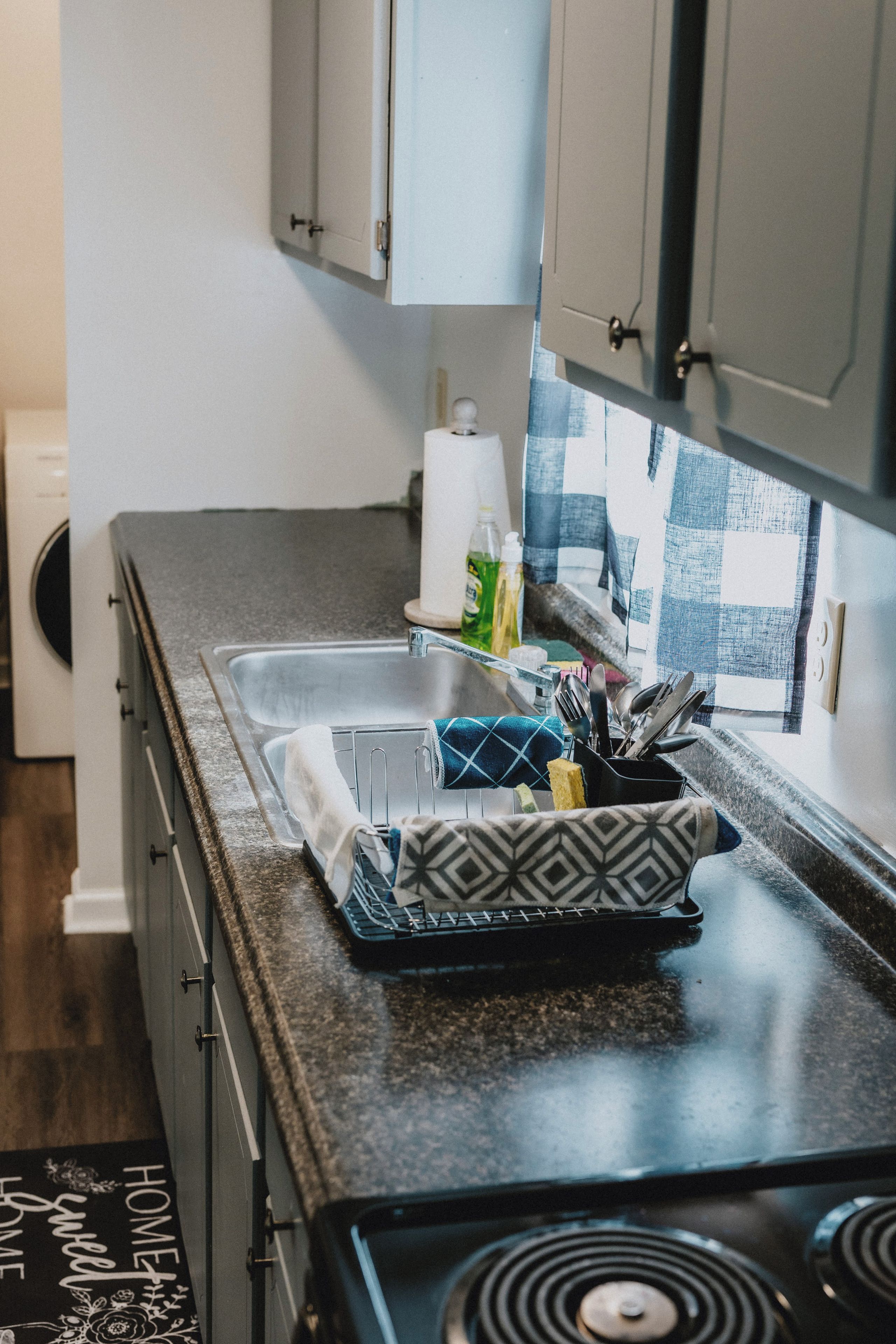 A kitchen with a granite countertop, a stove, and cabinets.