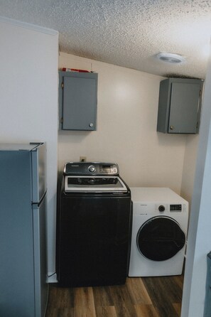 A compact laundry room with a washing machine, dryer, and a refrigerator.