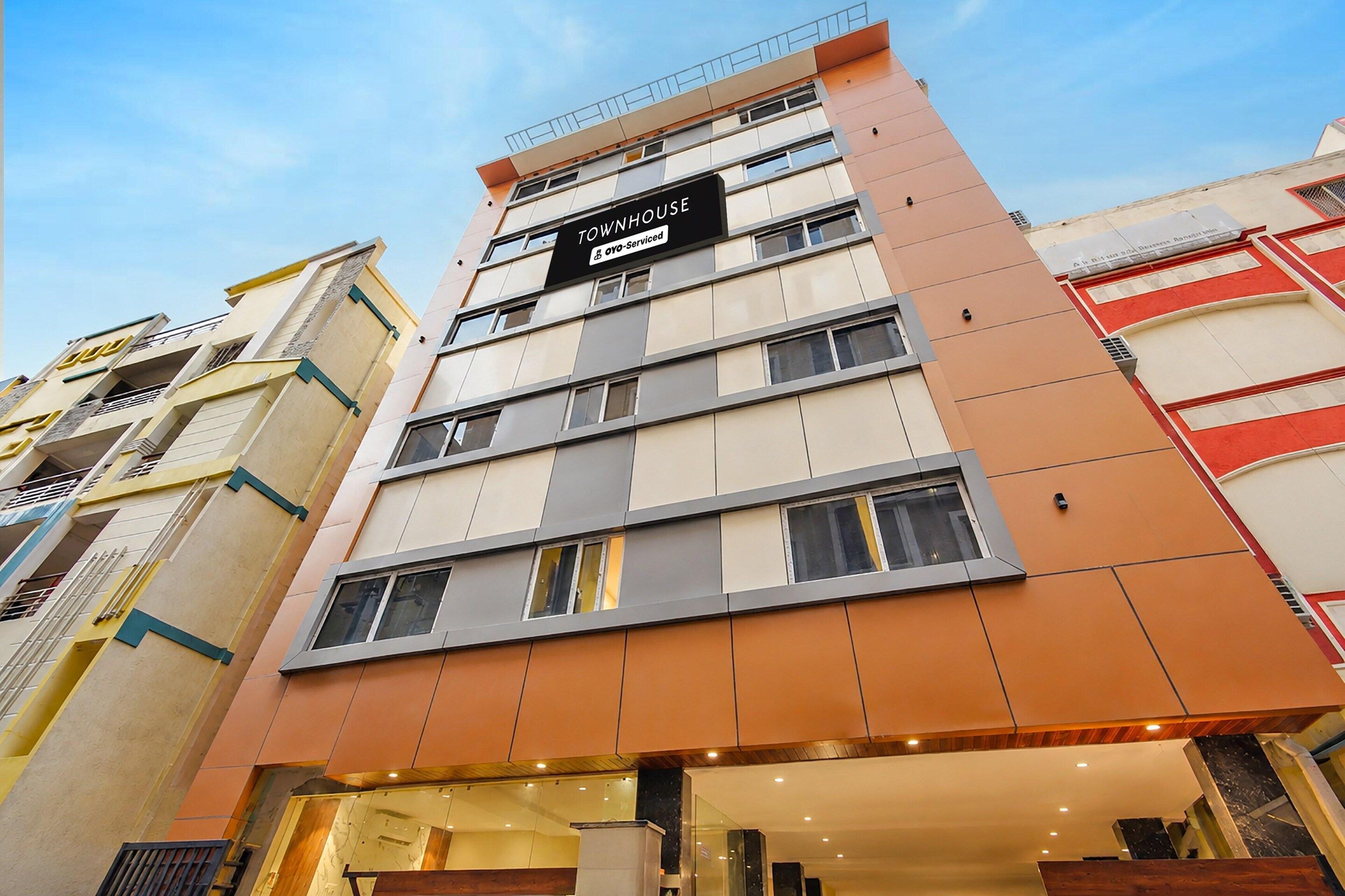 A multi-story hotel building with a sign indicating it is serviced by OYO.