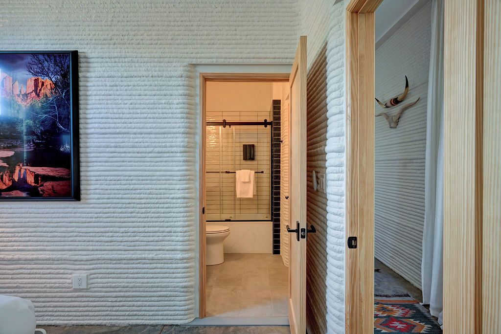 A bathroom with a toilet, a shower area, and a towel rack.