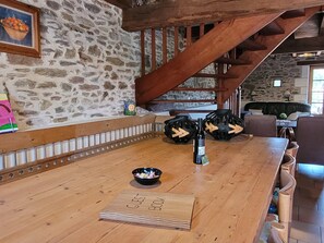A wooden bar area with a guest book, a bowl of snacks, and decorative wooden spheres. - Authentic, Spacious Gite for 10 (Saint-Saud-Lacoussiere)