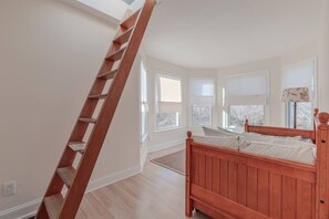 A bedroom with a wooden bed, a wooden ladder, and large windows. - Cape Mayzing! Pool, Sleeps 12, West Cape May (West Cape May)