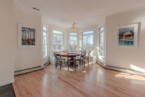 A dining area with a round table, chairs, and a hanging light fixture. - Cape Mayzing! Pool, Sleeps 12, West Cape May (West Cape May)
