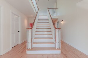 A staircase with white railings and wooden steps leading to an upper floor. - Cape Mayzing! Pool, Sleeps 12, West Cape May (West Cape May)