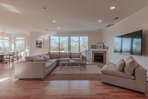 A spacious living room with a large sectional sofa, a coffee table, and a fireplace. - Cape Mayzing! Pool, Sleeps 12, West Cape May (West Cape May)