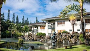 Un resort con piscina, cascada y estatua.
