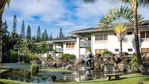 Un resort con piscina, cascada y estatua.
