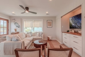 A spacious living room with a sectional sofa, a round coffee table, and a dining area with a wooden table and chairs. - •Bay Views• Close to Cape May & Wildwoods • (Middle Township)