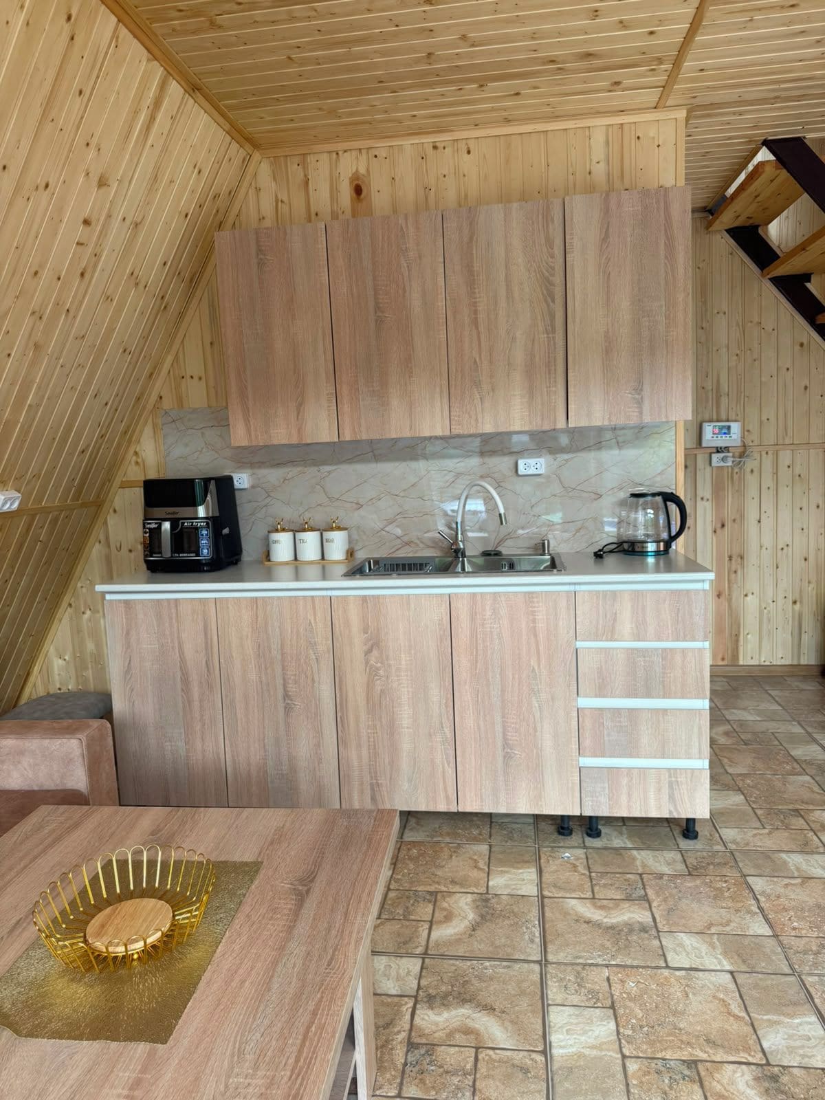A compact kitchen with wooden cabinets, a countertop, and a sink.