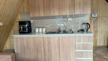 A compact kitchen with wooden cabinets, a countertop, and a sink.