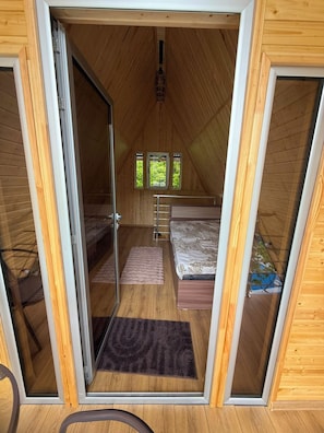 A cozy attic bedroom with a bed, a small window, and a wooden ceiling. - Getamej Eco Villa & Pool (Getamej)