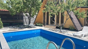 A swimming pool with a clear blue water, surrounded by a wooden deck and a lounge chair. - Getamej Eco Villa & Pool (Getamej)