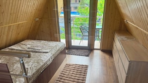 A compact bedroom with a bed, a small desk, and a view through a glass door. - Getamej Eco Villa & Pool (Getamej)