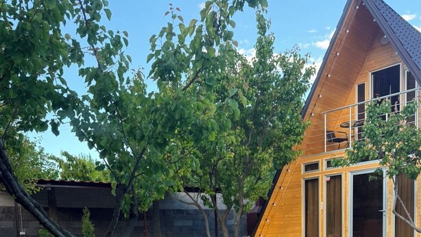 A modern house with a swimming pool, a wooden deck, and a garden with a bench and a tree. - Getamej Eco Villa & Pool (Getamej)