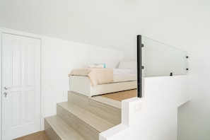 A bedroom with a bed, a bedside table, and a door. - Casa Limon - Amazing Townhouse in Benalmadena (Benalmádena)