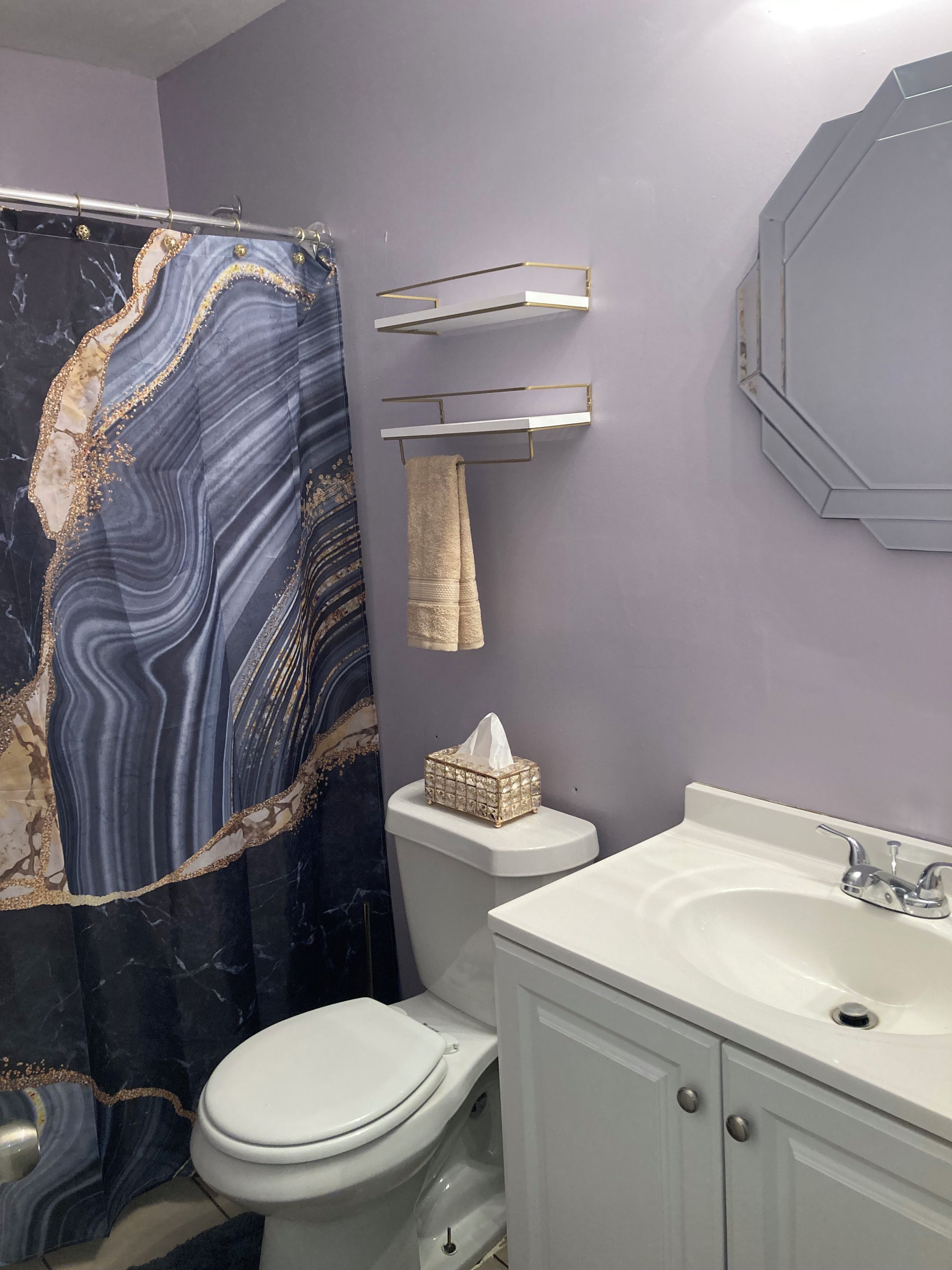 A bathroom with a toilet, sink, and a towel rack.