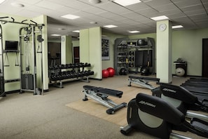 Una palestra con tapis roulant, manubri e macchinari per l'allenamento con i pesi.