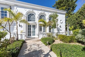 Un edificio blanco con ventanas arqueadas y una entrada central.