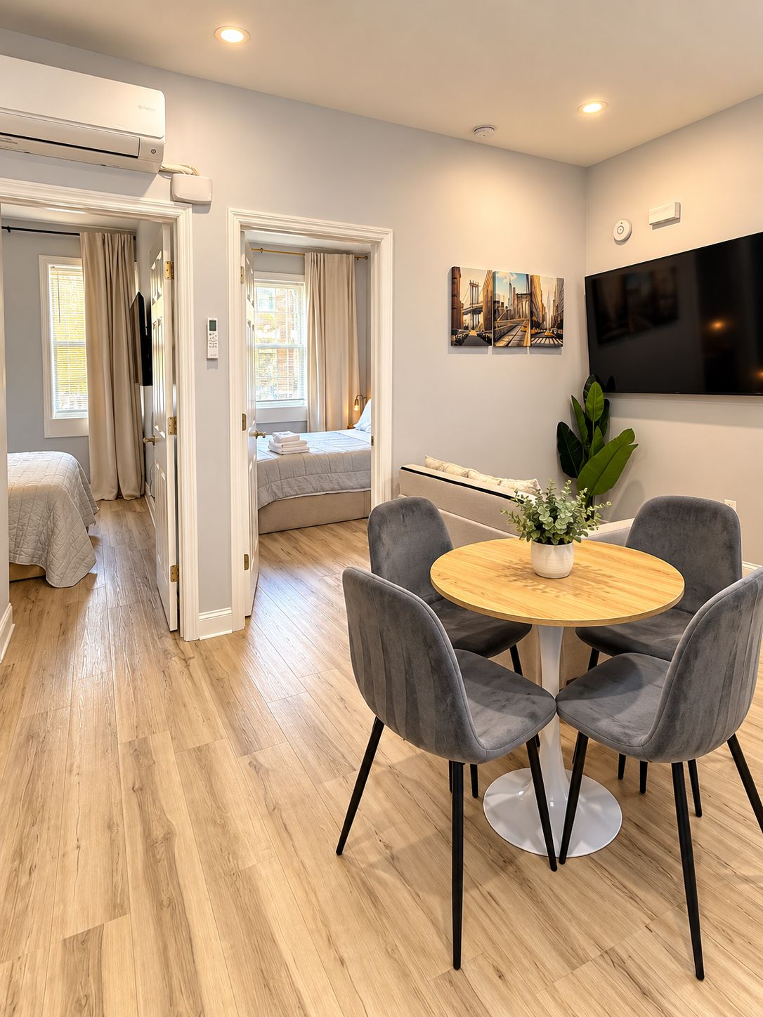 Una moderna camera d'albergo con zona pranzo, un letto, una TV e una pianta.