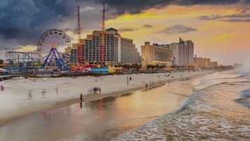 Une plage avec une grande roue et un immeuble imposant en arrière-plan.