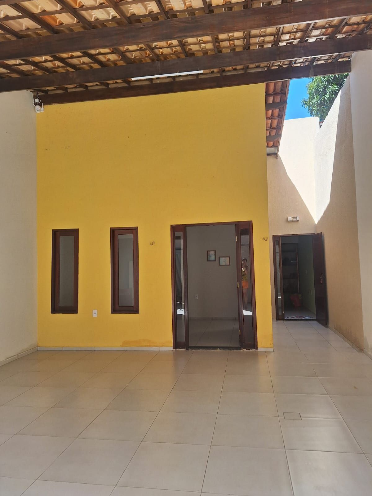 An interior space with a yellow wall, a door, and a tiled floor.