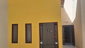 An interior space with a yellow wall, a door, and a tiled floor.