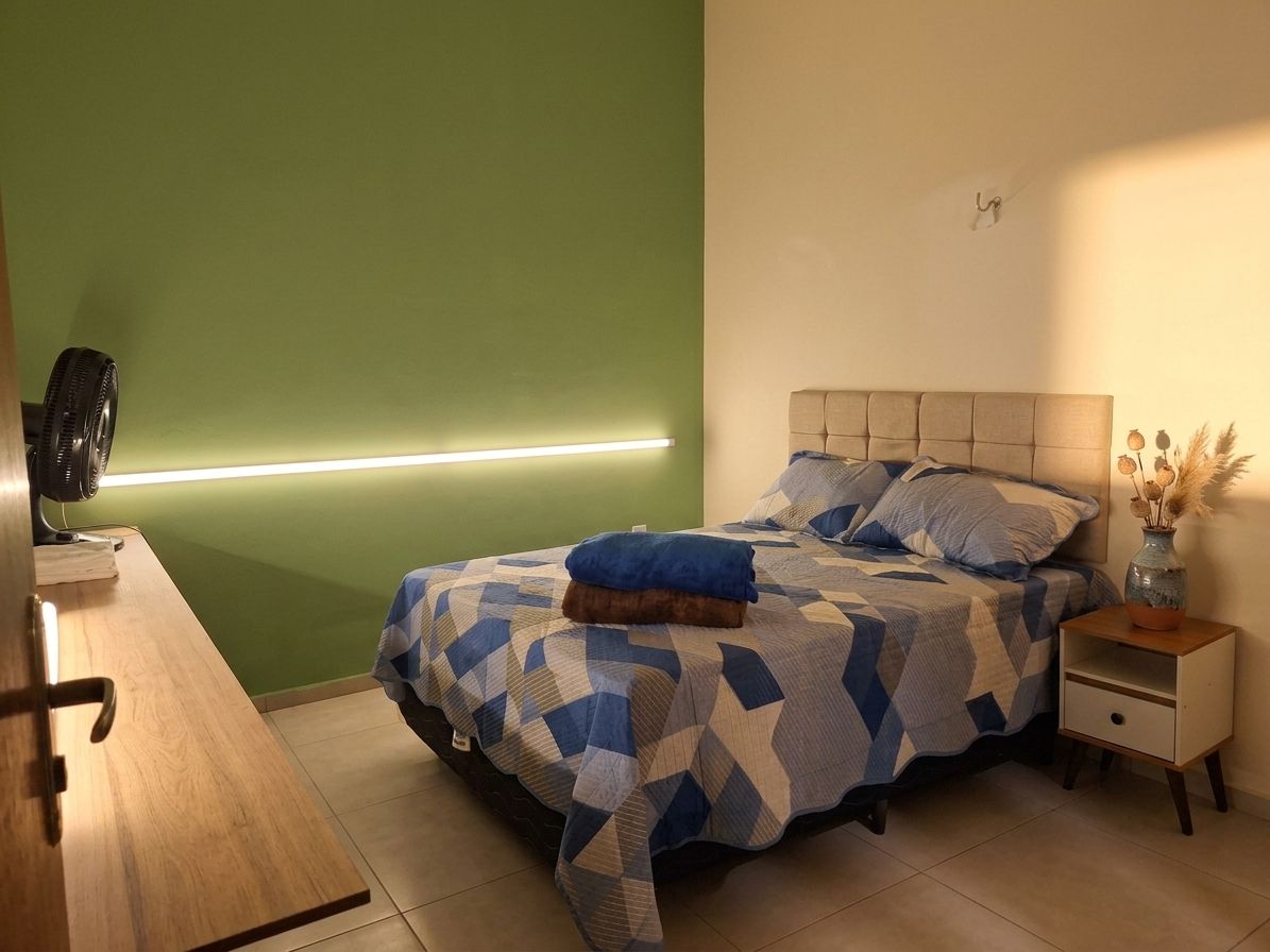 A bedroom with a bed, bedside table, and a nightstand.