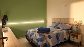 A bedroom with a bed, bedside table, and a nightstand.
