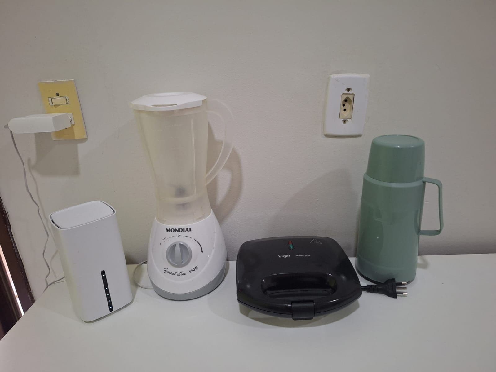 Een aanrecht met een blender, een koffiezetapparaat en een waterkoker.