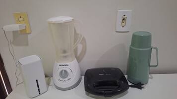 Een aanrecht met een blender, een koffiezetapparaat en een waterkoker.