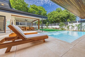 A modern outdoor pool area with lounge chairs and a dining set. - Luxury 3-Bedroom Villa with Private Pool, 100m from Playa Matapalo (Savegre)