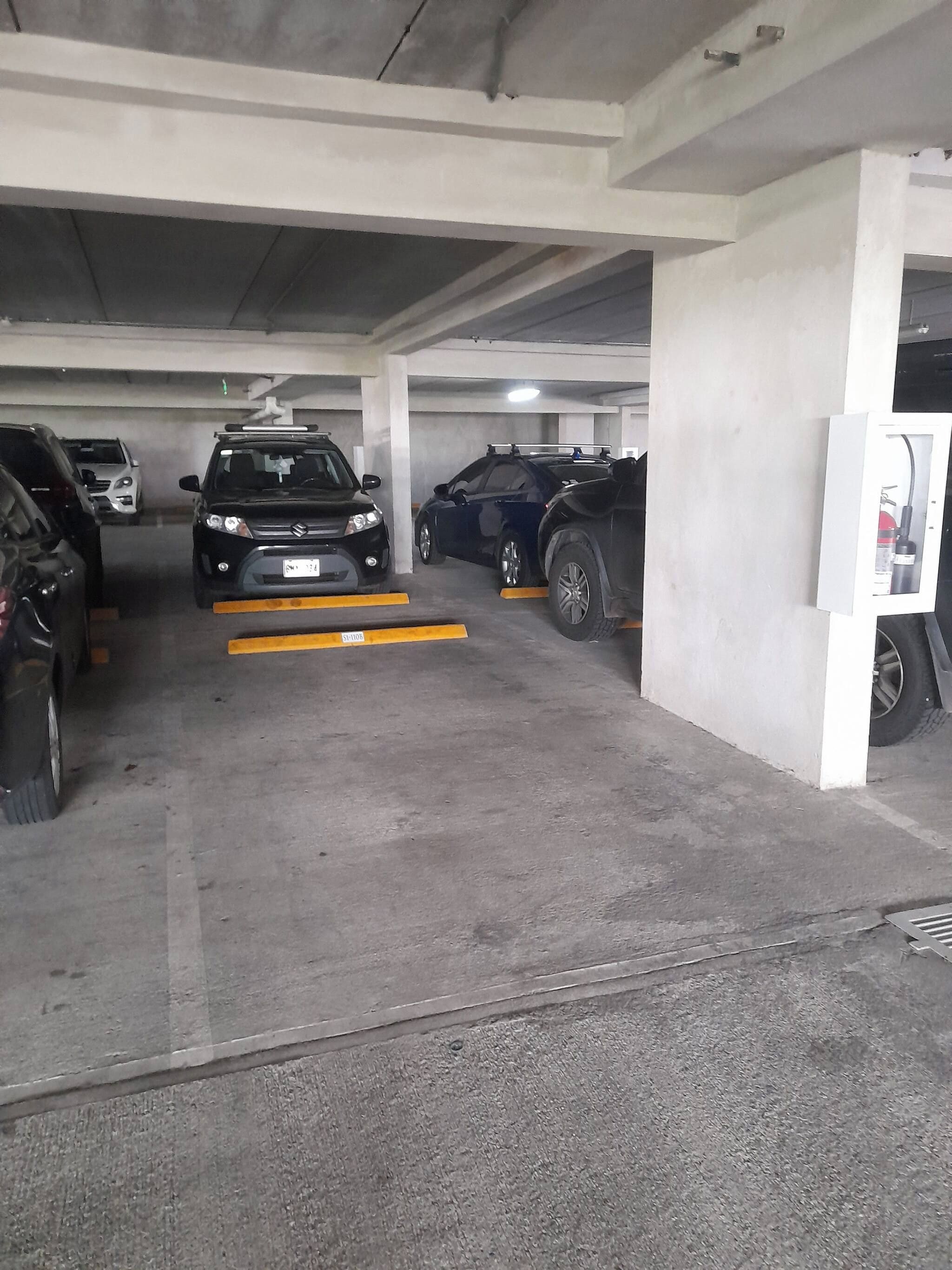 Un estacionamiento de varios niveles con pilares de hormigón y suelo plano.
