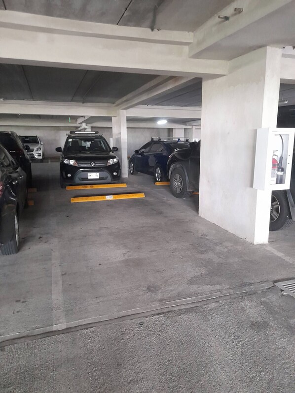 A multi-level parking garage with concrete pillars and a flat floor.