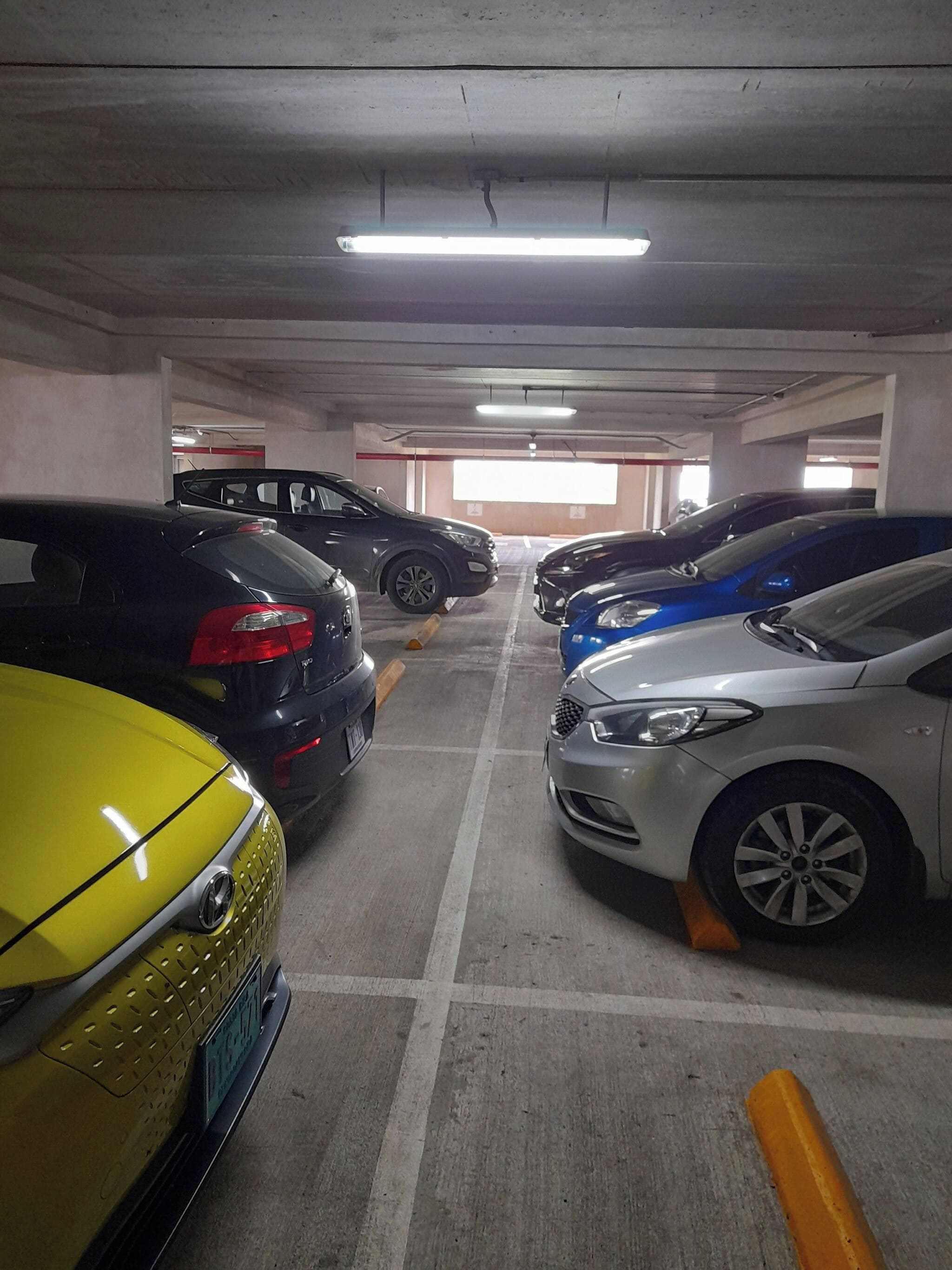 Eine Parkgarage mit mehreren Autos in dafür vorgesehenen Stellplätzen.