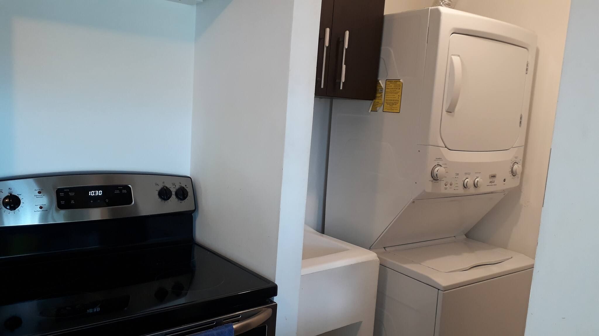 A compact laundry area with a washer and dryer, a stove, and a small countertop.