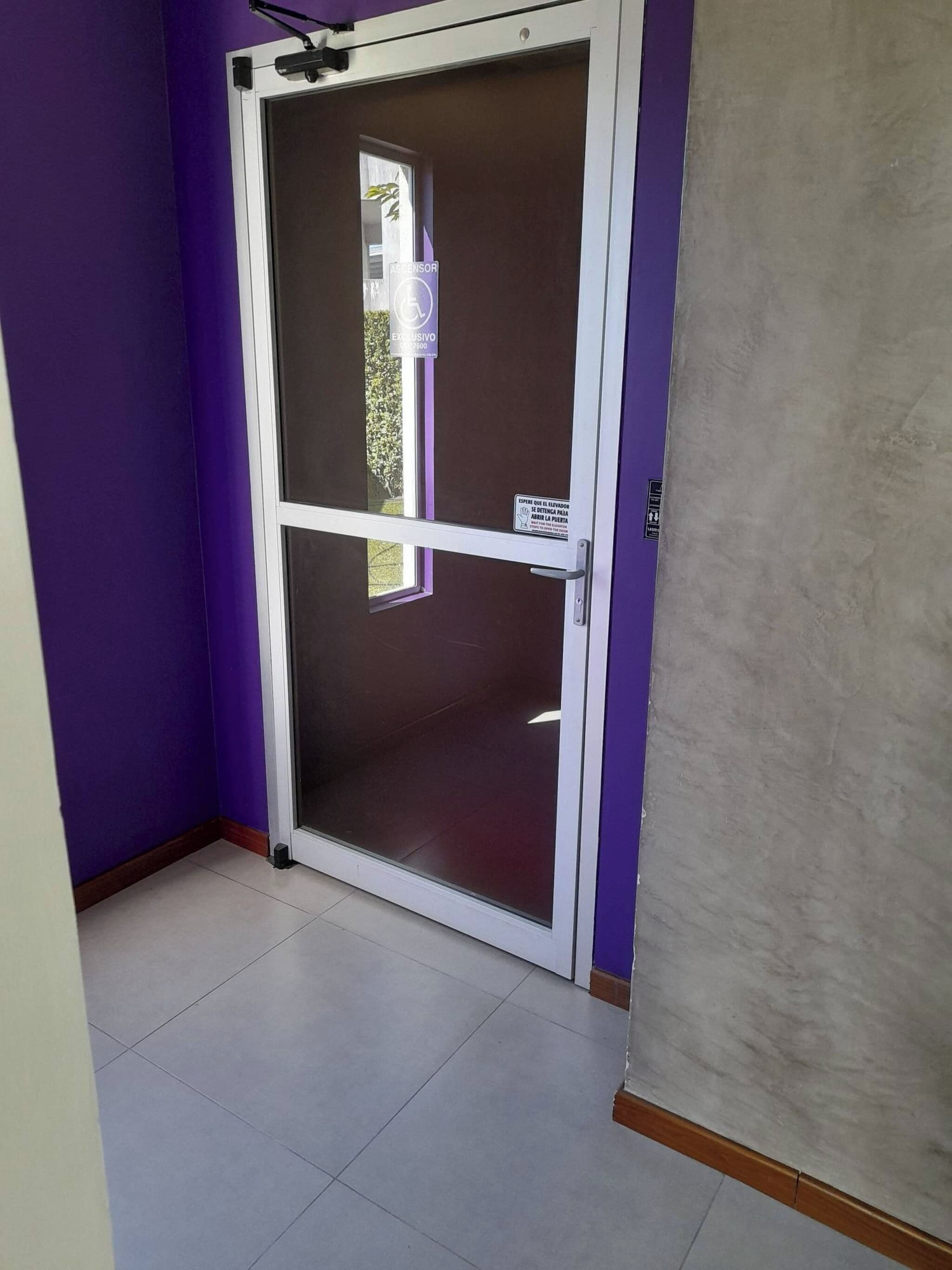 A room with purple walls, a sliding glass door, and a tiled floor.