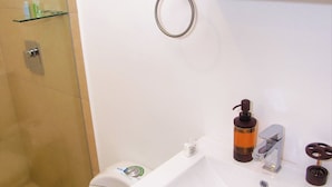 Un baño con inodoro, lavabo y ducha.