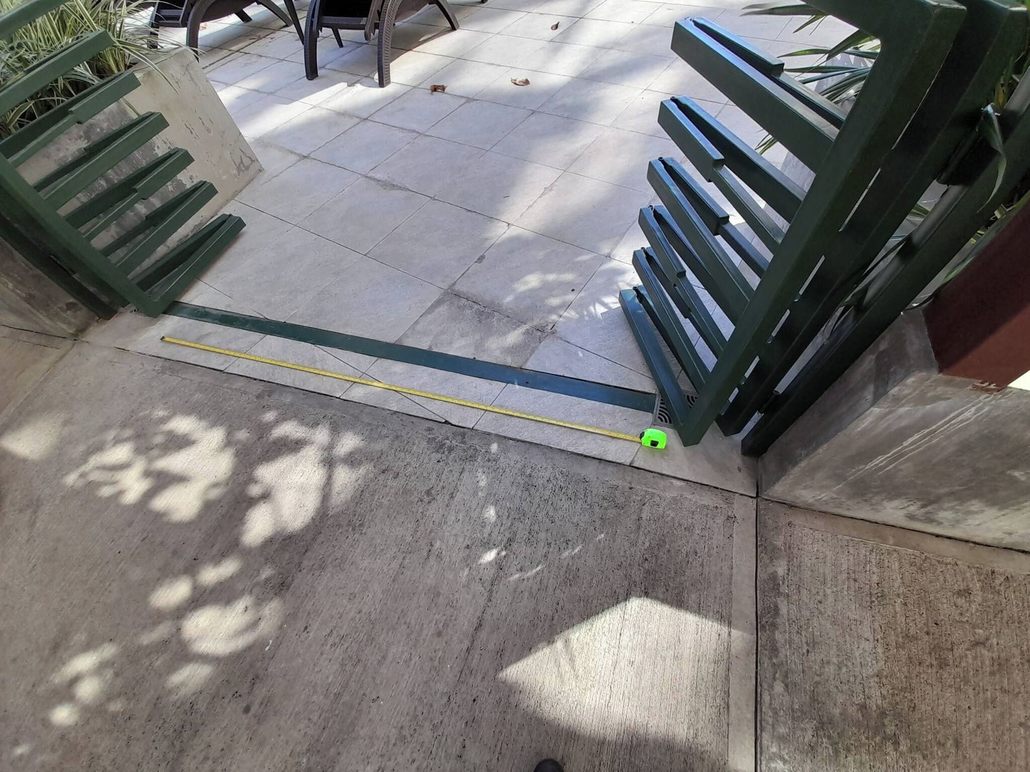 Un chemin bordé d’un objet vert et d’une ligne jaune tracée au sol.