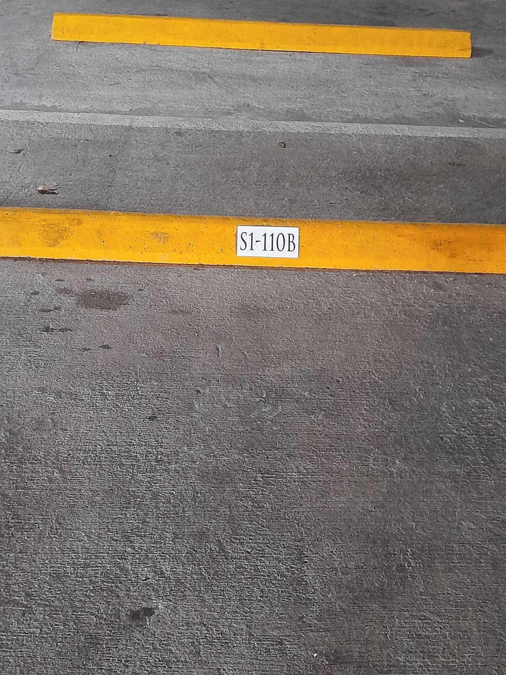 A parking area with a yellow line and a sign reading 'S1-110B'.