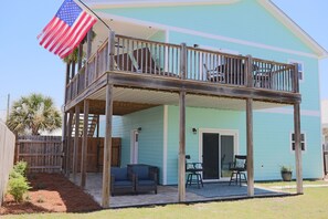 A two-story house with a balcony, a wooden fence, and a small garden area. - Aloha PCB: Walk to the Beach - Modern, Impeccable & Fully Stocked (Panama City)