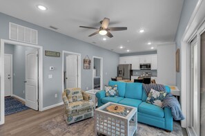 A modern living room with a blue sofa, a patterned armchair, and a coffee table. - Aloha PCB: Walk to the Beach - Modern, Impeccable & Fully Stocked (Panama City)