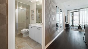Une salle de bain moderne équipée d’une douche, de toilettes et d’un meuble-lavabo.
