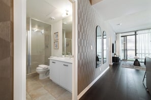 A modern bathroom with a shower, toilet, and vanity.