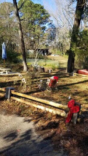Un parque con un banco de madera, un hidrante rojo y un área cercada.